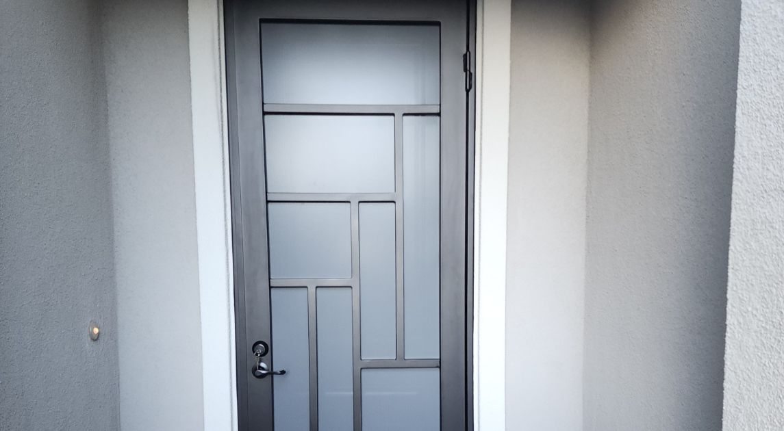 A sleek, modern-style, dark metal wrought iron door.